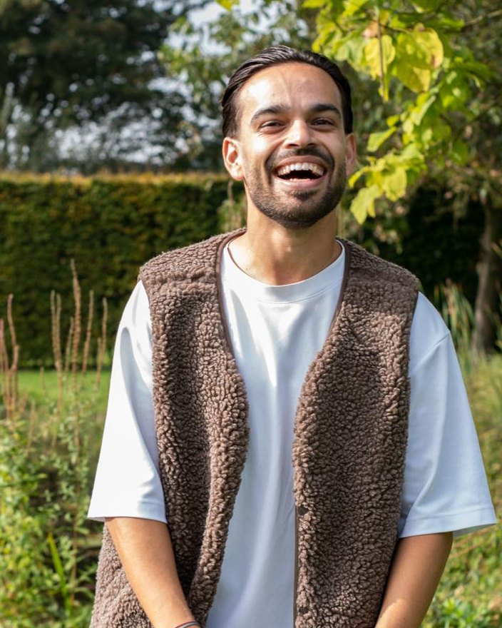 Alex van Overdijk, oprichter van AVO Workwear, lacht in een teddy bodywarmer